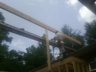Carpenter setting a ridge beam over a new addition frame — Ice Dam Removal by Roofing Brothers in East Troy
