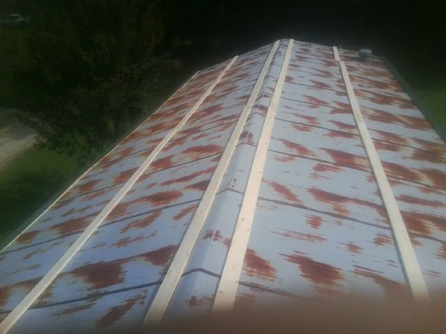 Rusted metal roof panels with new wood purlins before replacement — Storm Damage Roof Repair in East Troy by Roofing Brothers