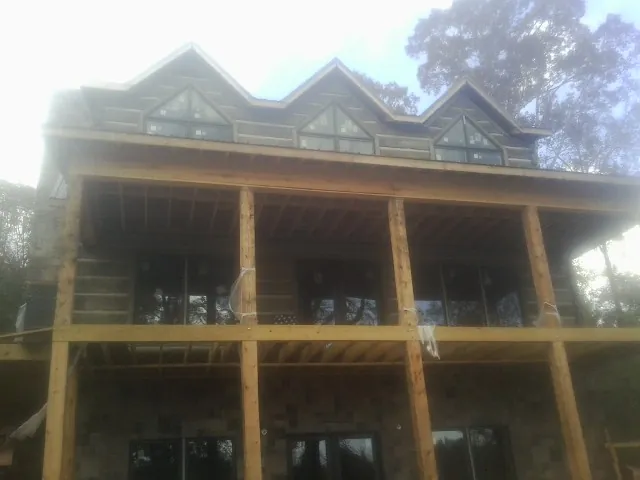 Dormers and porch framing on a large log home under construction — Roof Coating work by our crew in East Troy