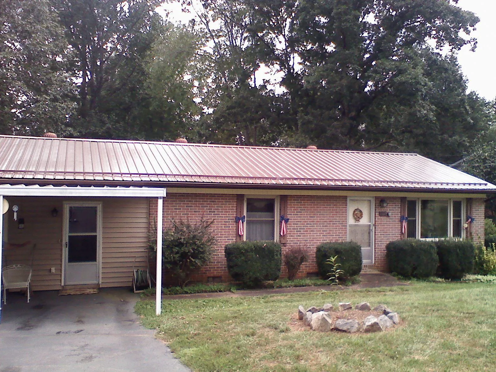Bronze metal roof and carport on a brick ranch home — Roof Repair work by our crew in East Troy