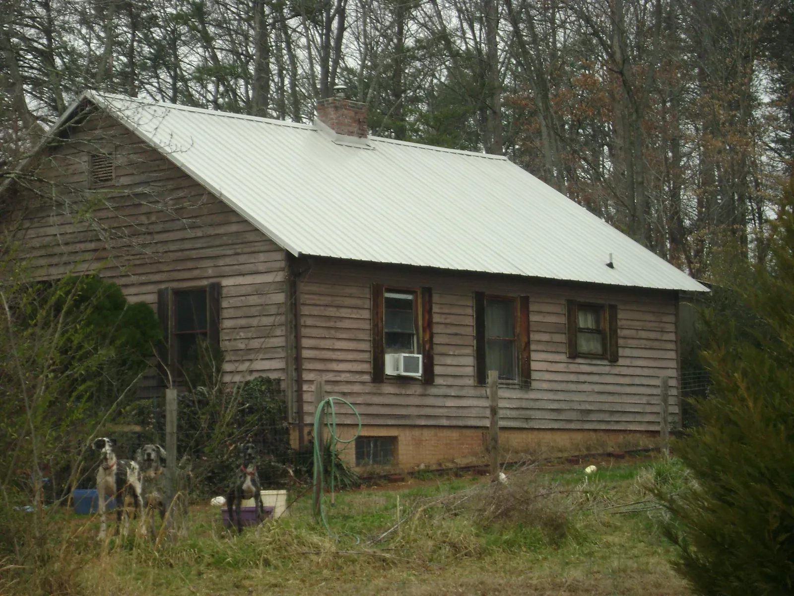 White metal roof on an old wood sided farmhouse, from a Asphalt Shingle Roof Repair job in East Troy