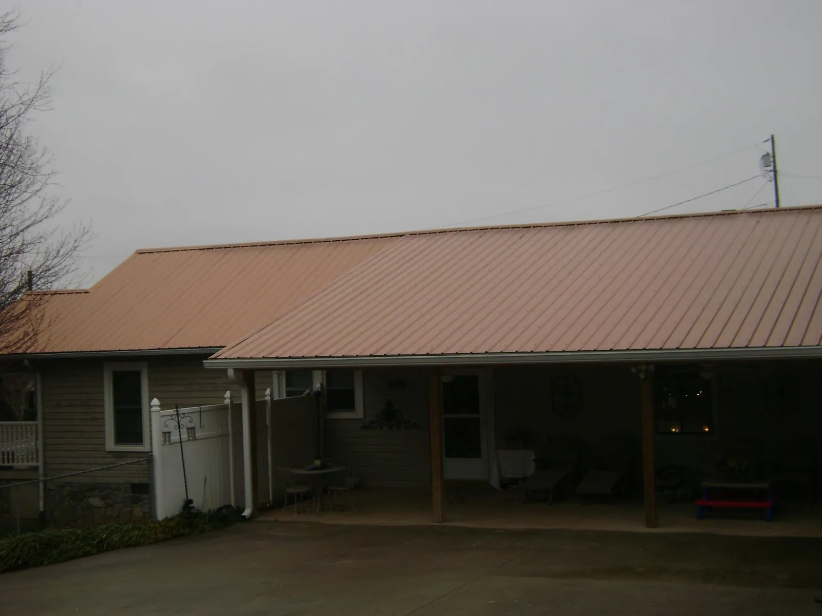 Copper toned metal roof over a wide covered patio in East Troy